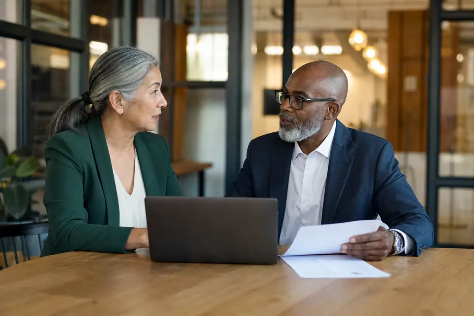 Nonprofit executive director and board treasurer meeting at a co-working space table.